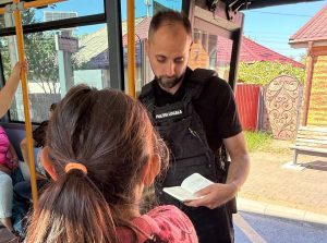 Controale în autobuzele din Bacău: zeci de călători prinși fără bilet și 10 amenzi aplicate de Poliția Locală 1 Polițist verificând biletele călătorilor în autobuzul din Bacău.