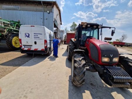 Tractor și mașină de înmatriculare în curtea fermei.
