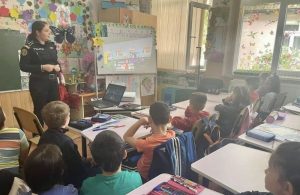 Polițist prezentând informații despre siguranță elevilor din Bacau.