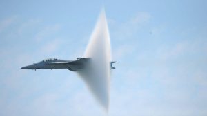 Avion de luptă supersonic zburând cu jet de apă.
