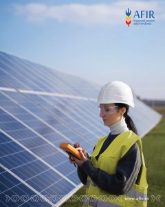 Femeie în echipament de protecție verificând panouri solare.