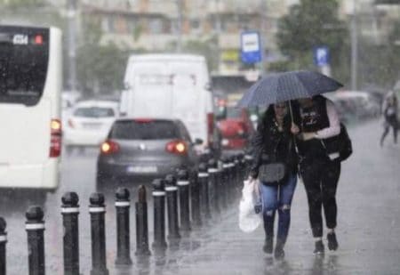 Vremea se schimbă radical: ploi, vijelii și primele ninsori la munte, în următoarele zile Persoane cu umbrele pe stradă în ploaie torențială în Bacău.
