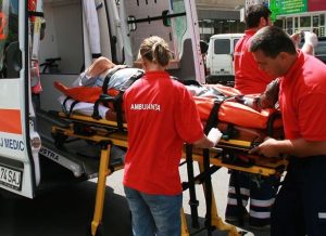 Echipaj de salvare cu voluntari pregătind un pacient pentru ambulanță.