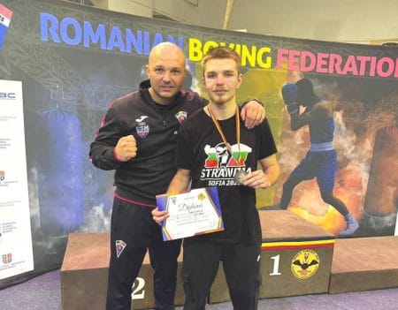 Boxer român cu antrenorul în ceremonia de premiere.