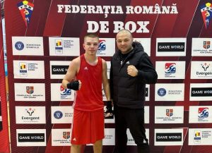 Boxer tânăr din Bacău alături de antrenor într-un cadru competițional.