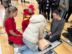 Tineri participând la curs de resuscitare în sala de sport.