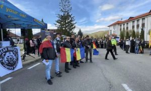 Călători și participanți țin steaguri naționale în timpul ceremoniei la Ziua Armatei.