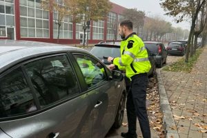Atenție unde parcați în Bacău: Poliția a aplicat zeci de amenzi și cere datele a 79 de proprietari de mașini 1 Agent rutier acordând documente unui sofer langa masina parcată pe trotuar.