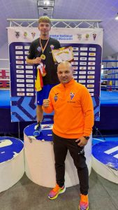 Vasile Scalco campion național U23 la 60 kg ținând medalionul de aur.