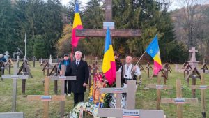 Români în ore omagiind militarii căzuți la Ziua Armatei la Valea Uzului.