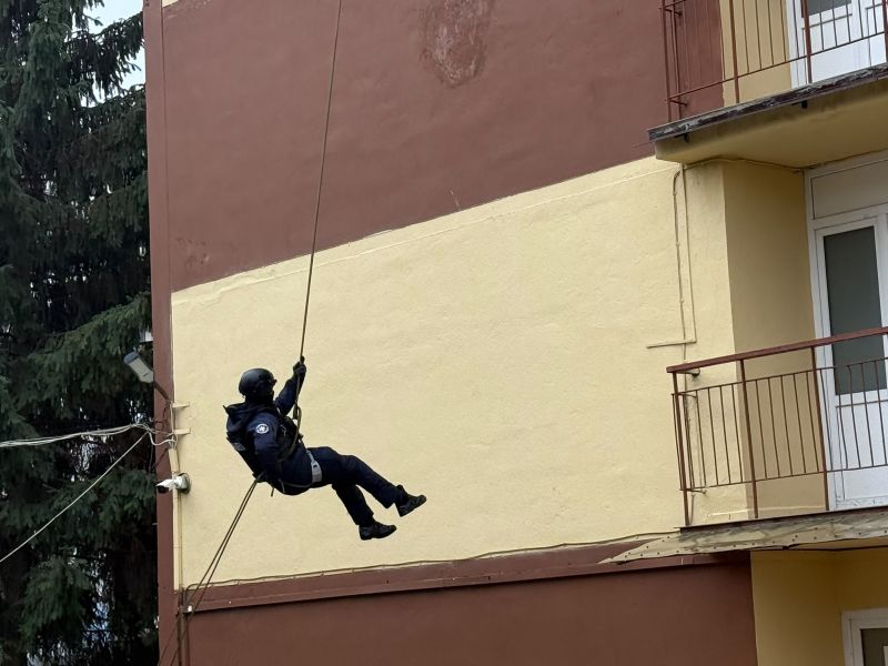 Copil în echipament de siguranță se plimbă pe o funie deasupra solului.