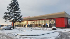 Orarul de iarnă la Aeroportul „George Enescu” Bacău: mai multe curse spre Londra, Roma, Torino, Milano și Dublin 2 Orar de iarnă la aeroport Bacău, exterior modern cu zăpadă și mașini parcate.