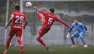Seria 1, Liga 3: Bacăul iese bine din etapa 10 – victorie pentru FC Bacău 2, egal spectaculos pentru Aerostar. Urmează derby-ul local 1 Jucător în echipament roșu executând pantă de lovire către minge, în timp ce goalkeeperul poartă ech.
