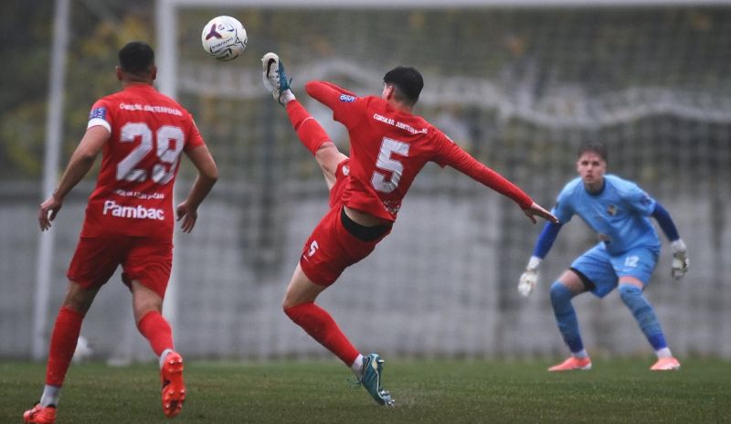 Seria 1, Liga 3: Bacăul iese bine din etapa 10 – victorie pentru FC Bacău 2, egal spectaculos pentru Aerostar. Urmează derby-ul local Jucător în echipament roșu executând pantă de lovire către minge, în timp ce goalkeeperul poartă ech.