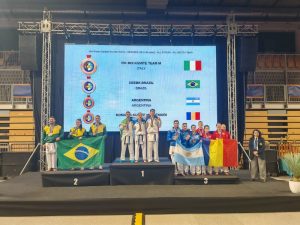 Dacă o întâlniți în misiune, evitați mișcările bruște! O polițistă din Bacău a cucerit trei medalii la Mondialul de Karate 1 Sportivi pe podium cu drapele, în fața ecranului de premiere.