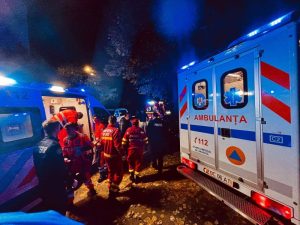 Ambulanțe în intersecția cu echipaje medicale în alertă, luminile albastre strălucesc.