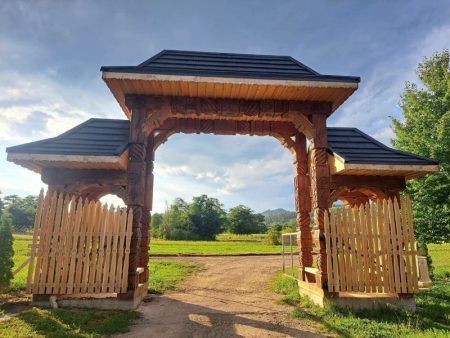Drumul spre unul dintre cele mai vizitate schituri din Bacău intră într-o nouă etapă. Ultima porțiune trece la județ Arhitectură tradițională din lemn la intrarea unui spațiu ritual în Bacău.