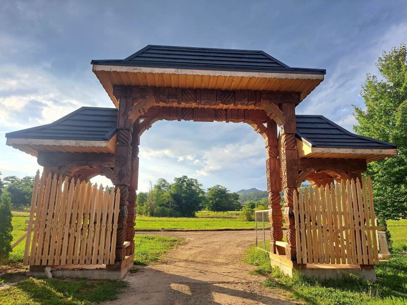 Drumul spre unul dintre cele mai vizitate schituri din Bacău intră într-o nouă etapă. Ultima porțiune trece la județ Arhitectură tradițională din lemn la intrarea unui spațiu ritual în Bacău.